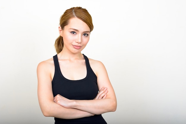 young beautiful Japanese woman against white wall