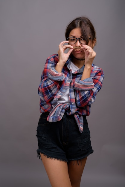 Young beautiful Kazakh woman against gray wall