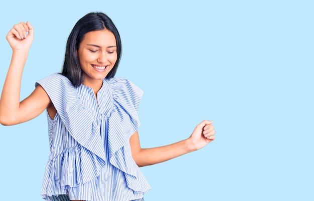 Young beautiful latin girl wearing casual clothes dancing happy and cheerful, smiling moving casual and confident listening to music