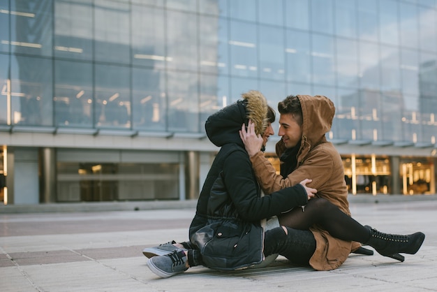 Young beautiful in love couple hugging each other in the middle of the street in a romantic way 
