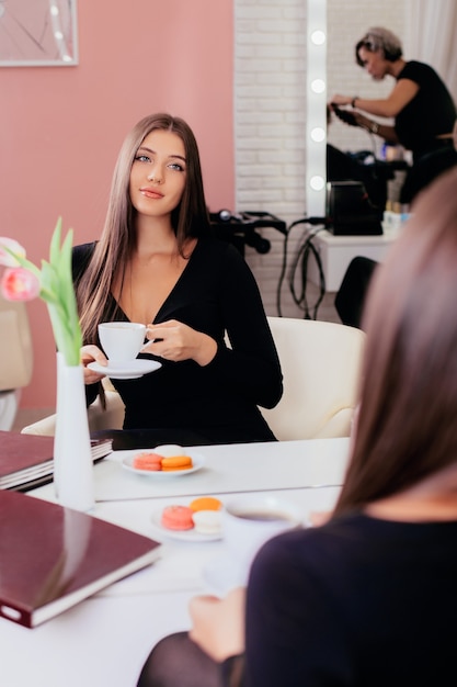 一杯のコーヒーと若い美しい豪華なブルネットの女性