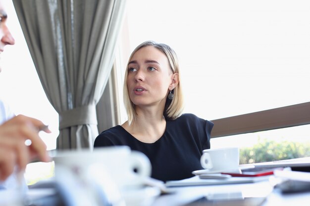 La giovane bella donna e uomo si incontrano nel settore dei caffè