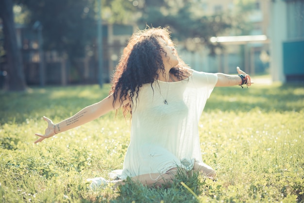 young beautiful moroccan curly woman listening music with smartphone