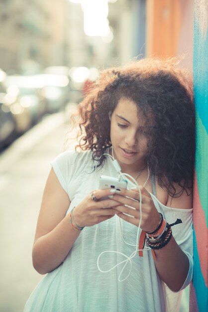 young beautiful moroccan curly woman using smartphone