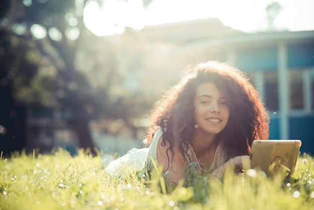 Photo young beautiful moroccan curly woman using tablet