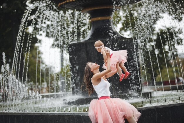 Young beautiful mother holding her little baby. Mom and infant. Family outdoors