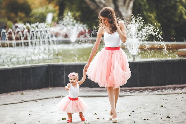 Young beautiful mother holding her little baby. Mom and infant. Family outdoors