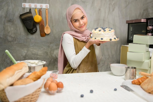 Young beautiful muslim woman is baking in her kitchen bakery and coffee shop business