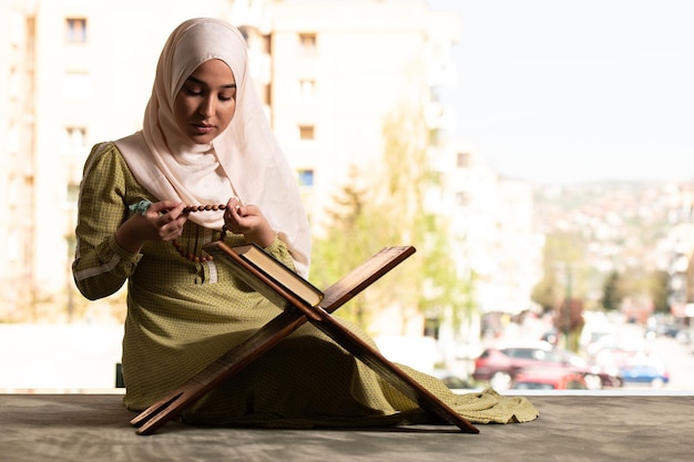 Young Beautiful Muslim Woman Praying With Quran