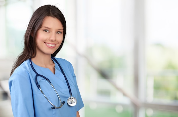 Young beautiful nurse on blurred background