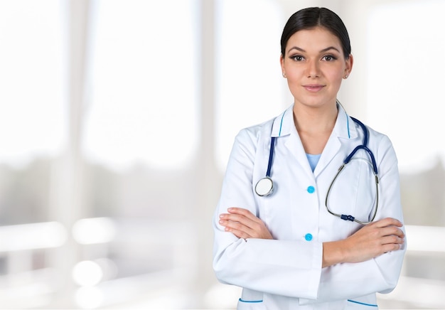 Young beautiful nurse on blurred hospital background