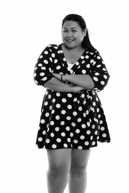 young beautiful overweight Asian woman isolated against white wall in black and white