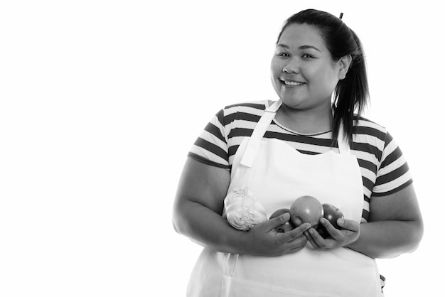 young beautiful overweight Asian woman isolated against white wall in black and white