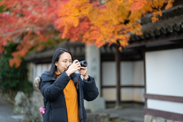 Young beautiful photographer with the professional camera taking photo beautiful