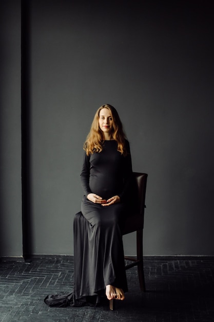 黒いドレスを着た若い美しい妊婦妊娠ファッションルックコンセプト