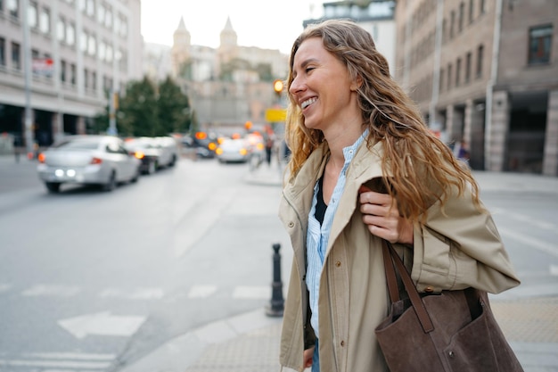 Young beautiful pretty woman walking along the street in modern city