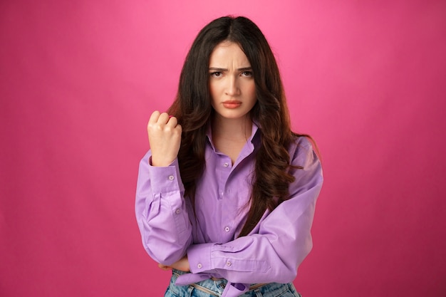 Young beautiful sad woman serious and worried pink studio background