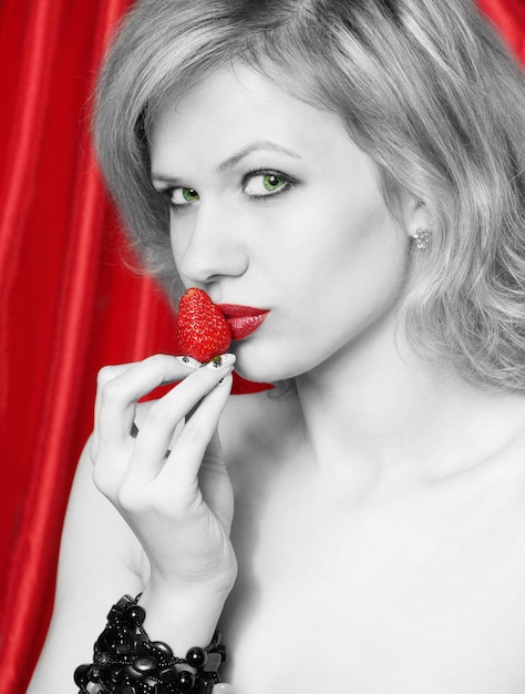 Young beautiful sexual blond eats the strawberries