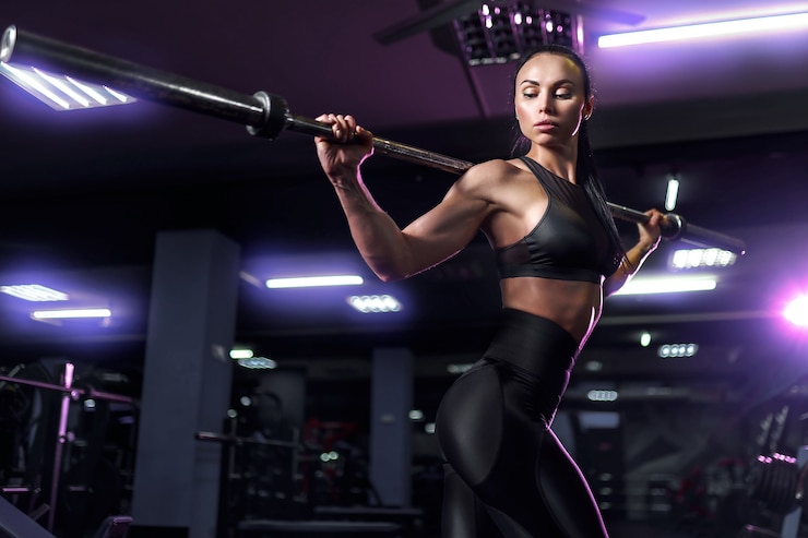 Photo young beautiful sexy brunette, athlete bodybuilder, exercises in the gym, in beautiful sportswear