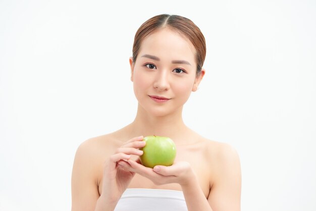 Young beautiful sexy girl bare shoulders and neck, holding big green apple to enjoy the taste and are dieting, healthy eating and organic foods, feeling temptation