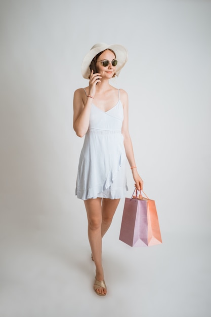 Young beautiful shopping girl using the phone