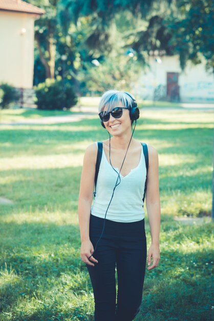 young beautiful short blue hair hipster woman with headphones music