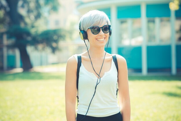 young beautiful short blue hair hipster woman with headphones music