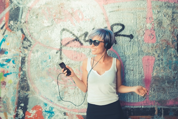 Photo young beautiful short blue hair hipster woman with headphones music