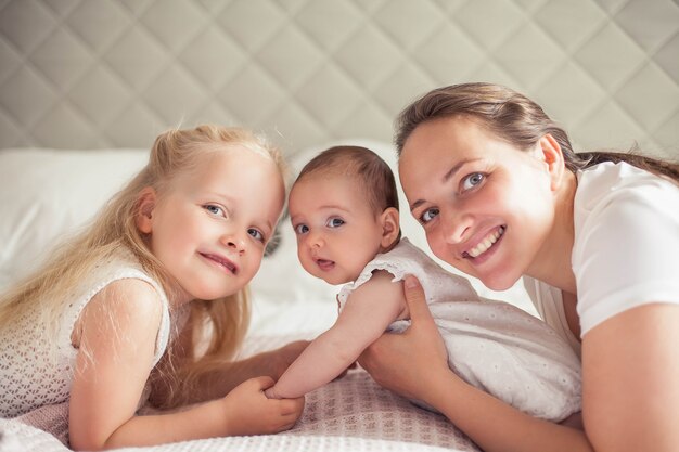 Young beautiful sister holds a baby