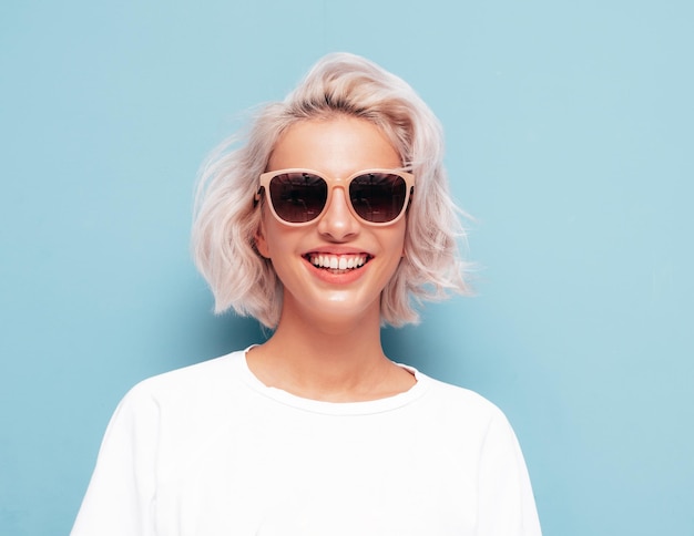 Young beautiful smiling female in trendy summer clothes Sexy carefree woman posing near in studio Positive blond model having fun and going crazy Cheerful and happy