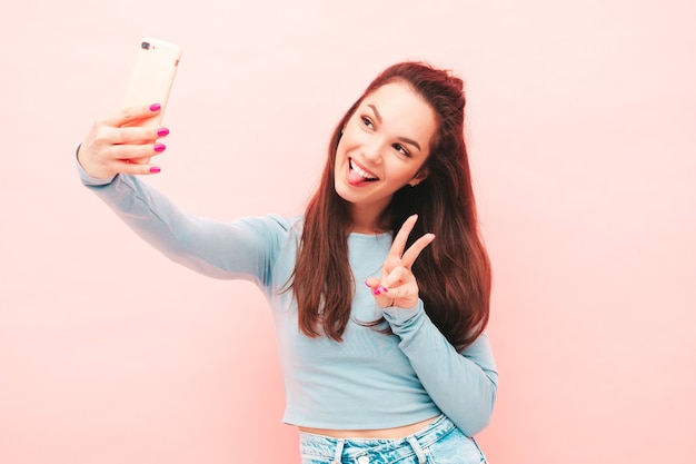 Young beautiful smiling female in trendy summer hipster clothes