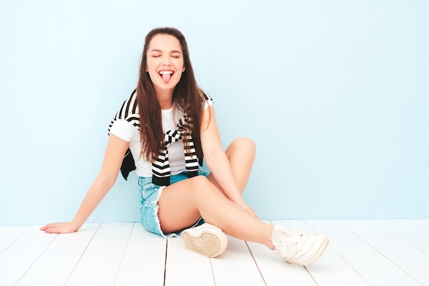 Young beautiful smiling female in trendy summer hipster clothes