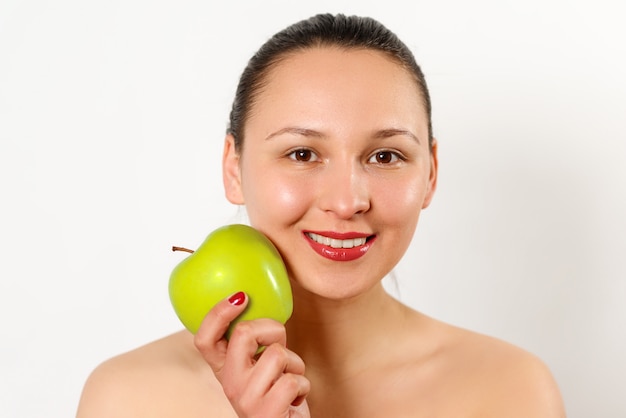 Young beautiful smiling woman touches the apple to face. isolated on white.