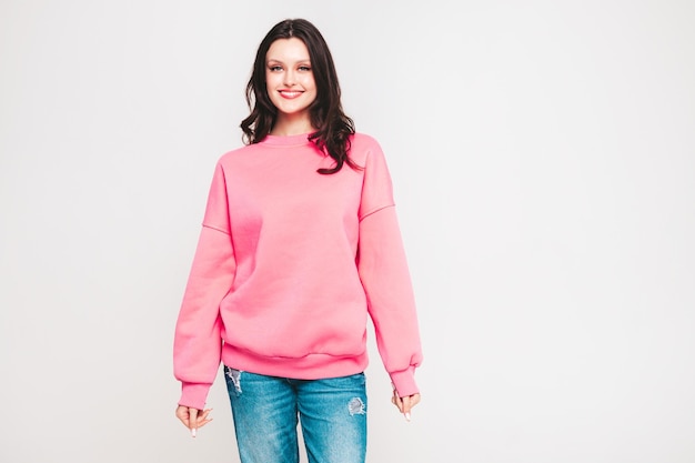 Young beautiful smiling woman in trendy jeans and sweater clothes Woman posing in studio