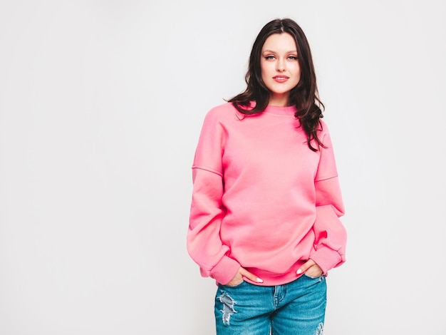 Young beautiful smiling woman in trendy jeans and sweater clothes Woman posing in studio