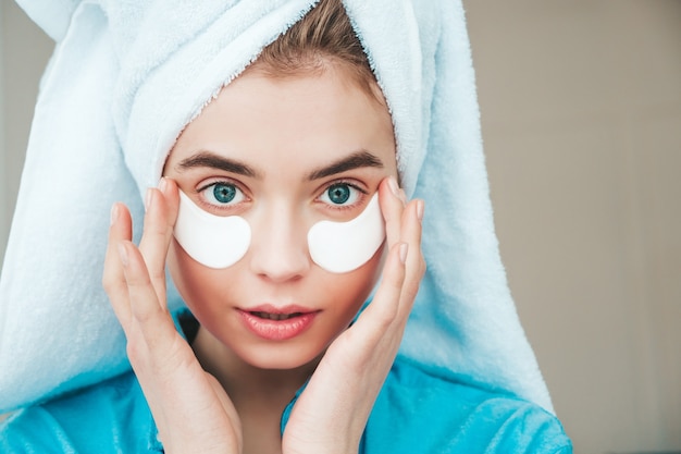 Young beautiful smiling woman with patches under eyes