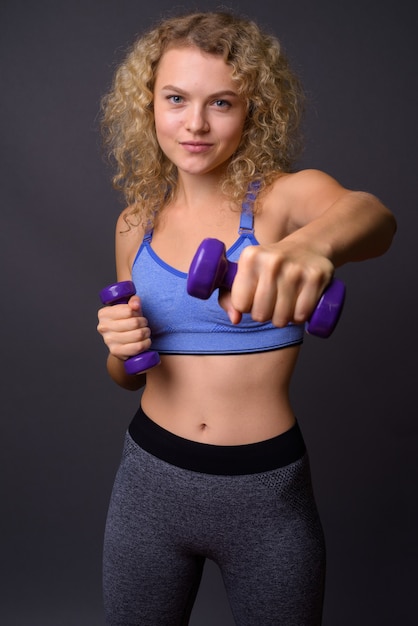 Young beautiful sport woman ready for gym holding dumbbells