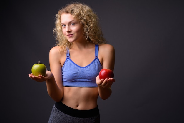 Foto giovane bella donna sportiva pronta per la palestra che tiene mela sana