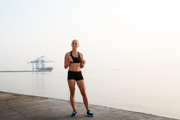 Young beautiful sportive boxer girl training at seaside