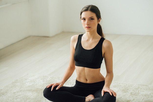 Young beautiful sporty woman home doing sports training. Studio shot.