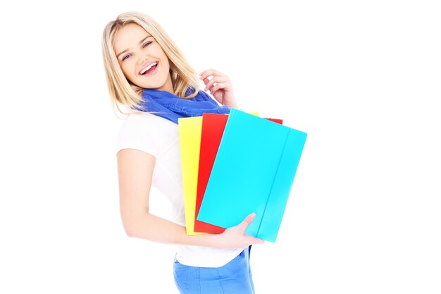 Photo a young beautiful student holding folders and smiling over white background