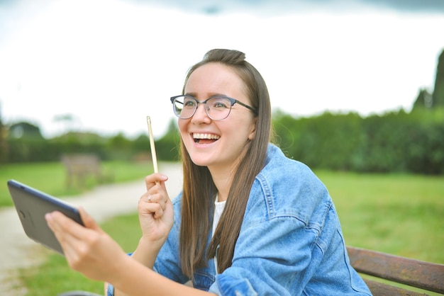 若い美しい学生は屋外で学んでいます