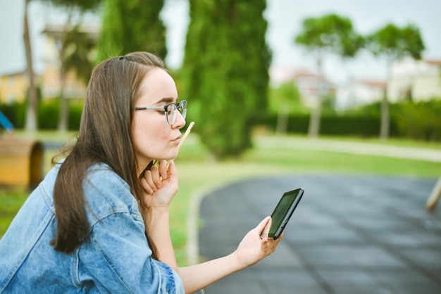 Giovane e bella studentessa sta imparando all'aperto