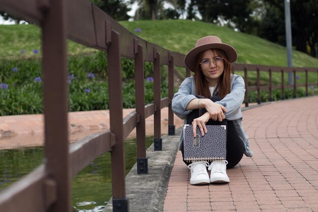 Photo young beautiful student reading a book in a park in a university library