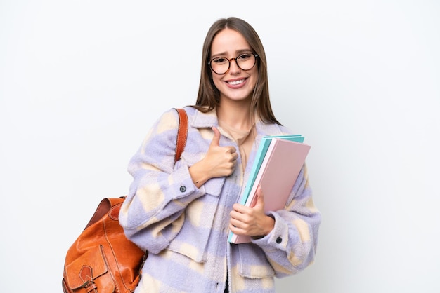 親指ジェスチャーを与える白い背景に分離された若い美しい学生女性