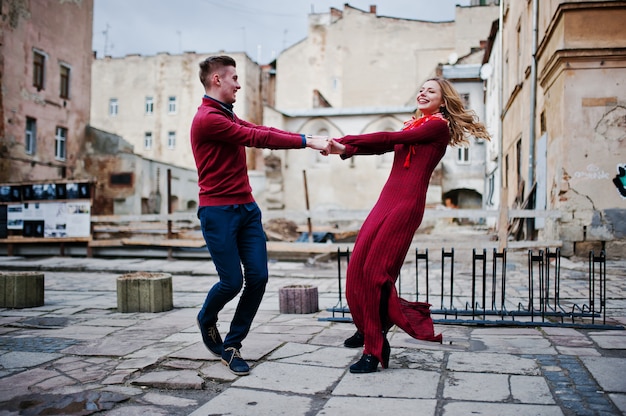 Young beautiful stylish fashion couple in a red dress in love story at the old city