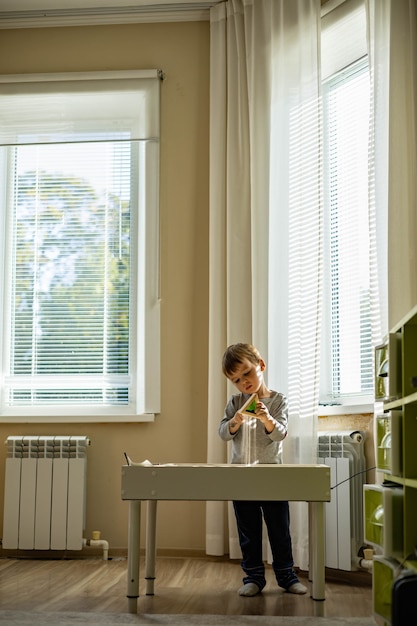 Young beautiful stylishly dressed girl works at home in the office takes notes in a paper diary