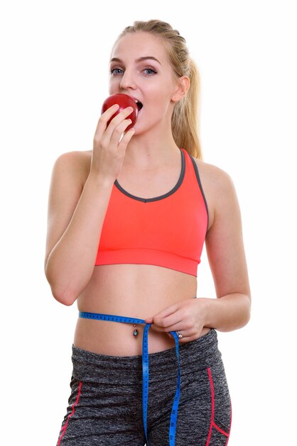 young beautiful teenage girl eating red apple