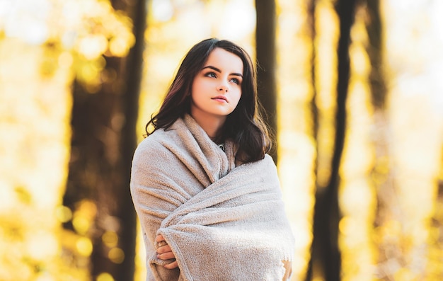 Young beautiful teenager girl surrounded autumn leaves outdoor