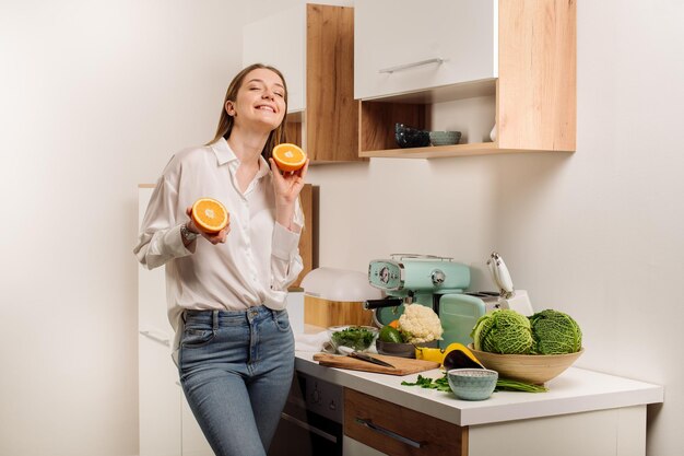 젊고 아름다운 채식주의자 소녀나 블로거가 집에서 과일 야채와 채소로 아침을 준비합니다. 건강한 식생활에 관한 블로그